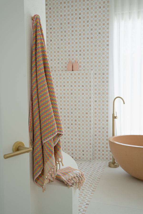 Bathroom with a bathtub, towel, and decorative wall.