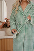 Person wearing a green and white striped robe in a bathroom setting.
