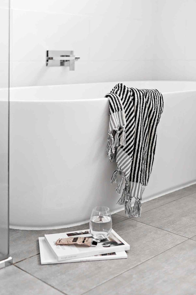 Black and white striped bathroom set with bath mat