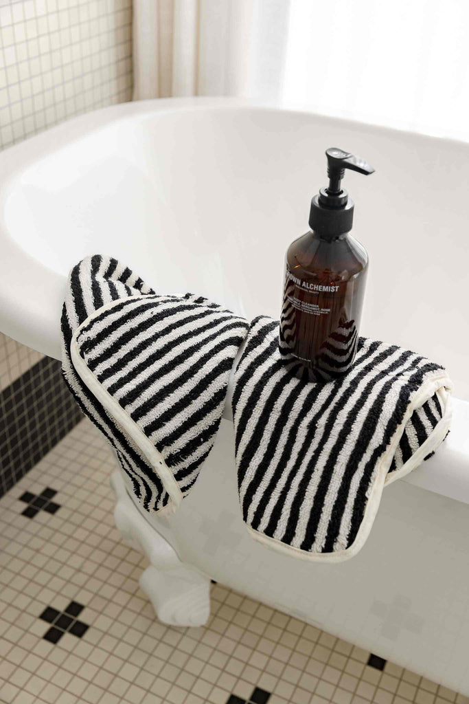 Black and white striped bathroom set with bath sheets, mat, and hand towel