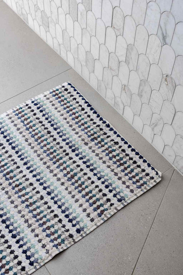 Eucalyptus Bathroom Set features a woven cotton bath mat with raised pompom stripes in white, grey, blue and green