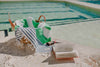 Apple green and navy striped Flamenco Turkish towel with tassels by poolside