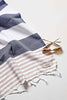 Navy and beige striped Flamenco Turkish towel with fringes and sunglasses