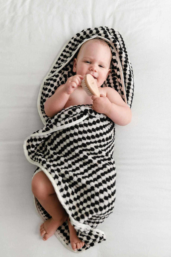 Baby wrapped in black and white pompom Turkish cotton hooded towel