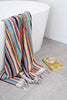 Turkish cotton bath towel multicolour stripes draped over bathtub